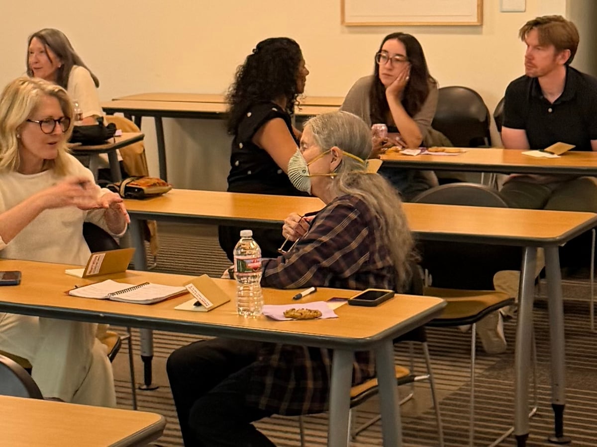 Workshop participants talking together at classroom tables